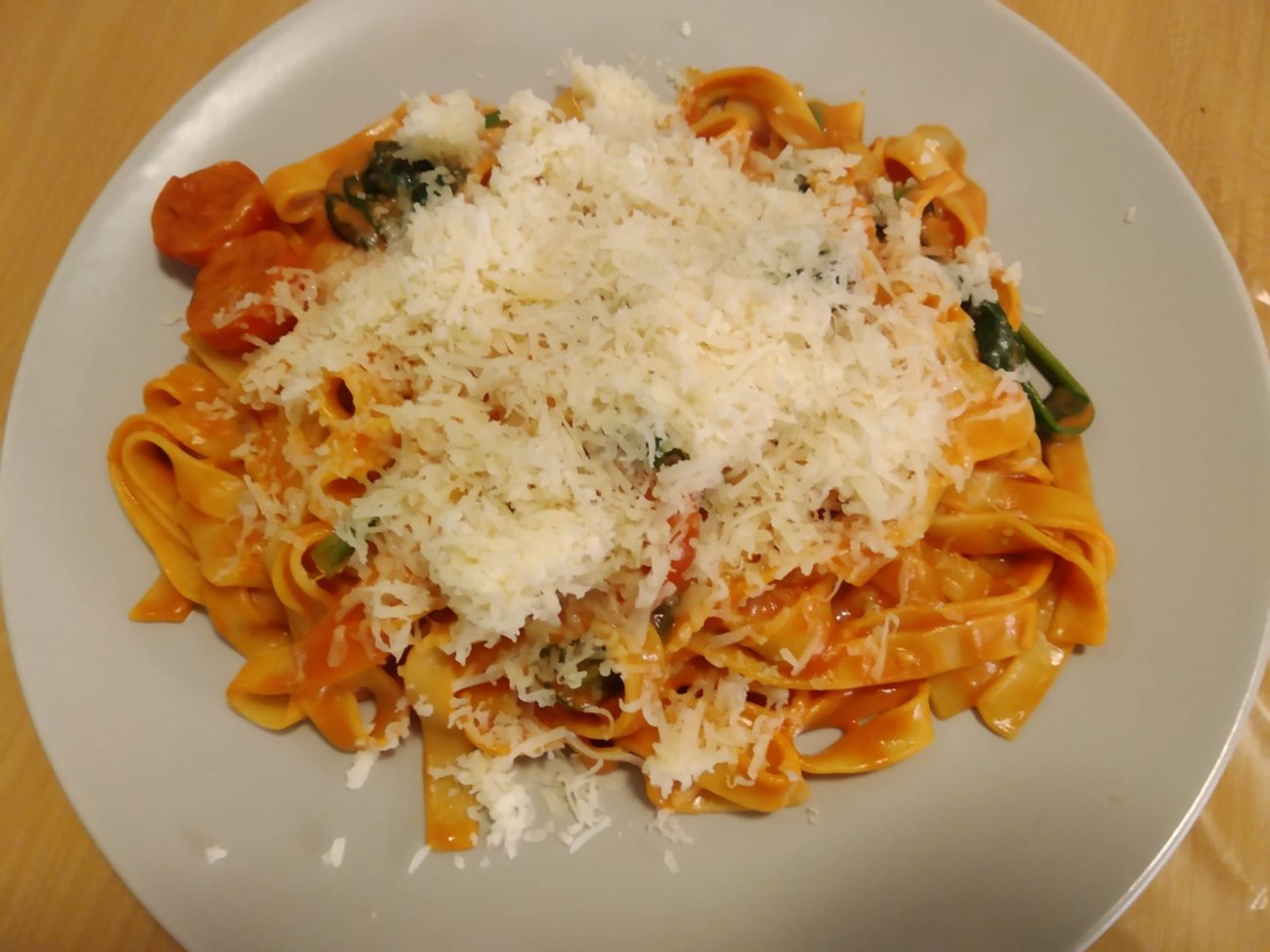Tallarines with tomato sauce, cherry tomatoes, and spinach